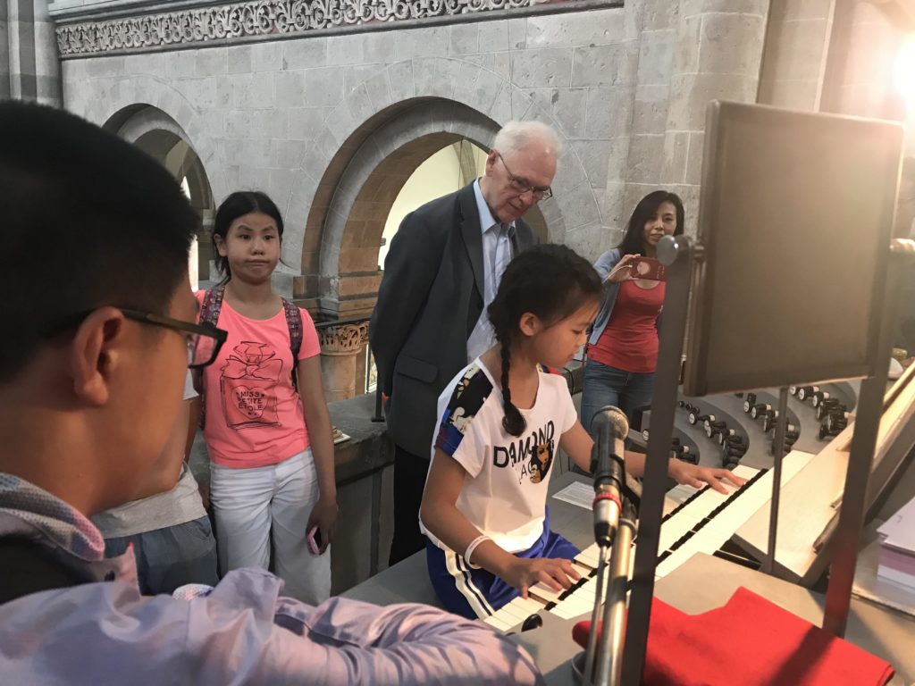 Chinesische Musikschülerin unter Anleitung von Monsignore Bretschneider  an der Orgel der Stankt Andreaskirche zu Köln